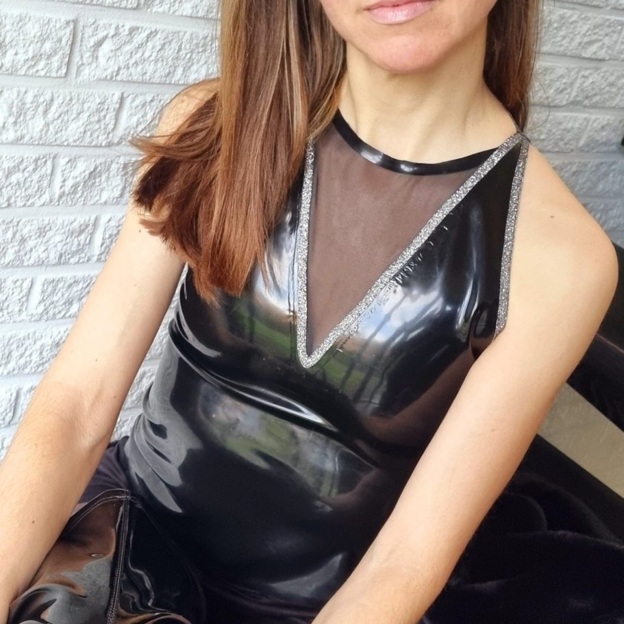 Latextop in schwarz mit schwarzem Mesheinsatz und Glitzerrändern, kombiniert mit Shorts und Overknees.