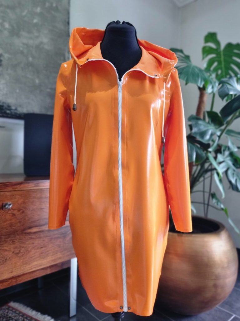 Kapuzenkleid aus Latex Ein oranges Kapuzenkleid aus Latex mit weißem Reißverschluss.